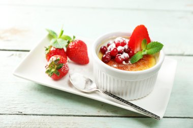 Creme brulee tatlısı peçeteye renk ahşap arka plan üzerinde taze çilek Çilek ile