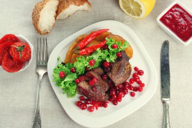 Tabakta, açık renkli kızılcık soslu lezzetli kavrulmuş et