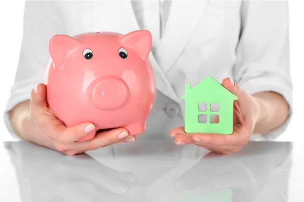 Woman holding model of house and piggy bank close up — Stock Photo, Image