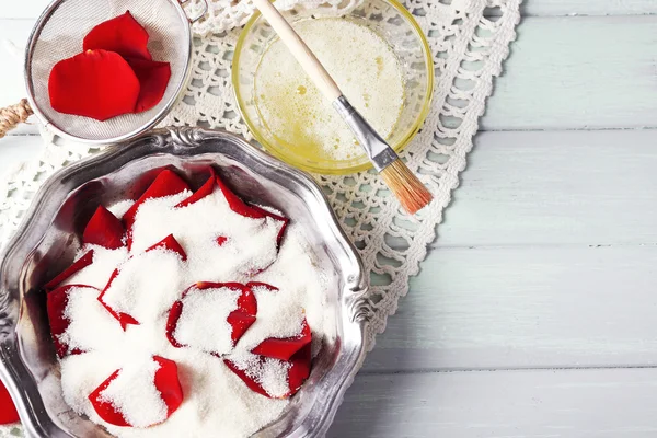 Making candied rose flower petals with egg whites and sugar, on wooden background — Stock Photo, Image