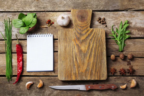 Open receptenboek met verse kruiden en specerijen op houten achtergrond — Stockfoto