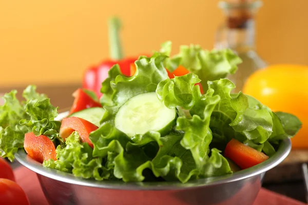 Färska grönsaker sallad i skål på bordet på nära håll — Stockfoto