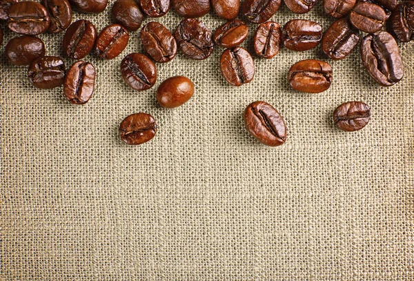 Frame of coffee beans on color sackcloth background — Stock Photo, Image