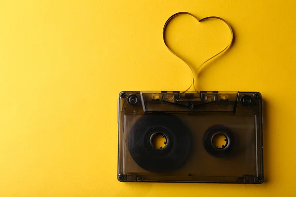 黄色の背景にハートの形で磁気テープとカセット — ストック写真
