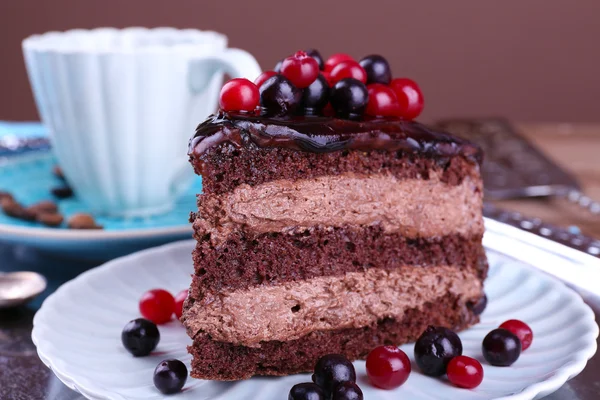 Delicious chocolate cake with berries on plate on table close up — Stock Photo, Image