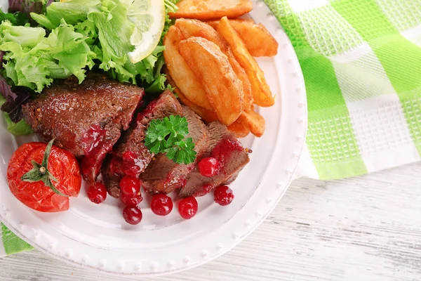 Tasty roasted meat with cranberry sauce and roasted vegetable