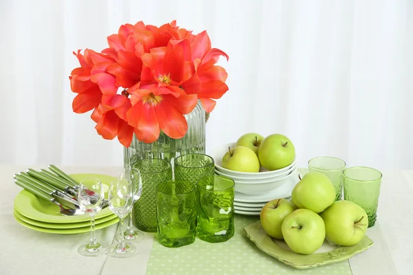 Configurações de mesa coloridas e flores de tulipa em vaso na mesa, no fundo claro — Fotografia de Stock