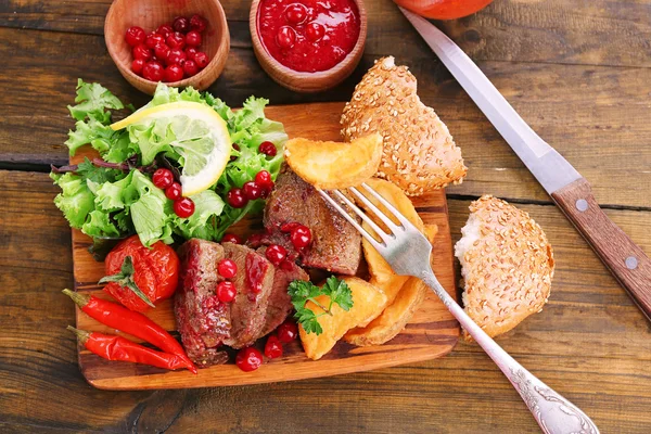 Beef with cranberry sauce, roasted potato slices — Stock Photo, Image