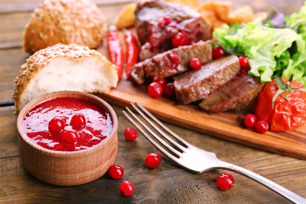 Βόειο κρέας με τη σάλτσα των βακκίνιων, φέτες πατάτας ψητό — Φωτογραφία Αρχείου
