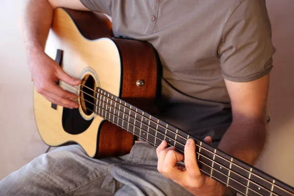 Young man playing on acoustic guitar — Stock Photo, Image