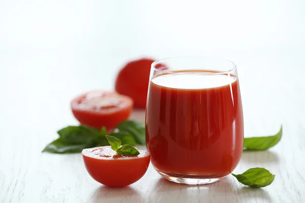 Jugo de tomate y tomates frescos en primer plano de mesa de madera —  Fotos de Stock