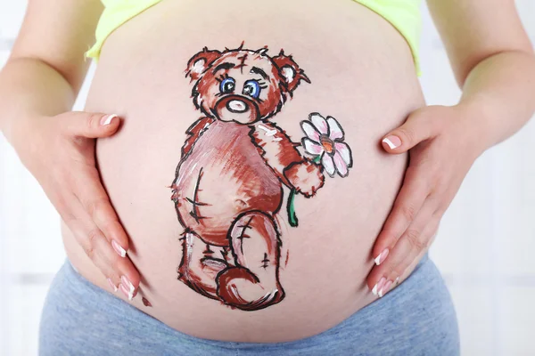 Tatuazy na brzuchu w ciąży kobieta na jasnym tle — Zdjęcie stockowe