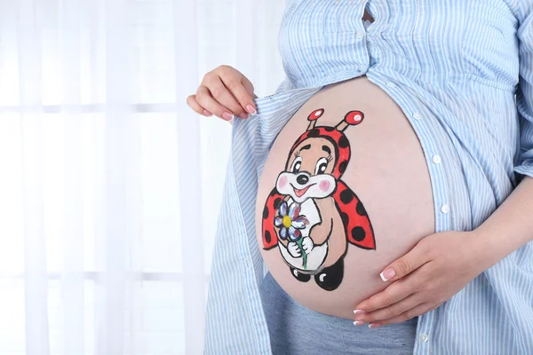 Art corporel sur le ventre de la femme enceinte sur fond clair — Photo