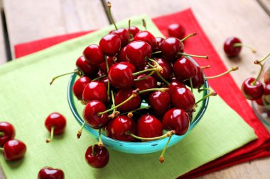 Sweet cherries in bowl on table close up clipart