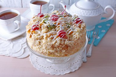 Tereyağı kek kiraz stand ve renk ahşap arka plan üzerinde tablo ayarı ile