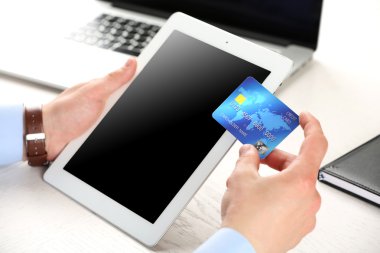 Kredi kartı ve tablet tutan adam