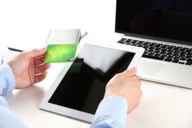 Kredi kartı ve tablet tutan adam