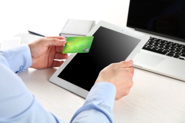 Kredi kartı ve tablet tutan adam