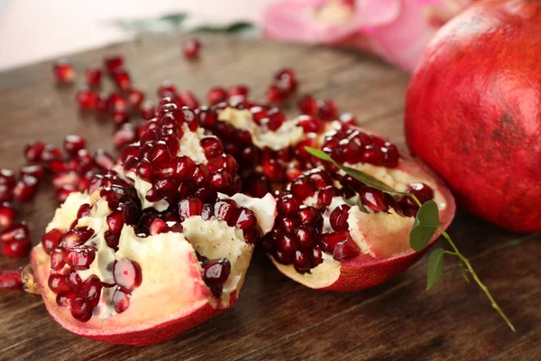 Pomegranate seeds on wooden table — Stock Photo, Image