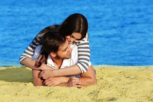 Jeune couple allongé sur la plage — Photo