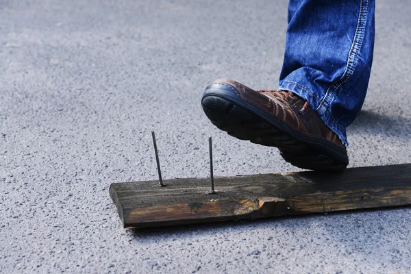Worker steps on nail outdoors — Stock Photo, Image