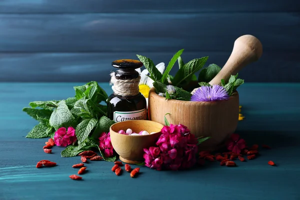 Otlar, meyveler, çiçekler ve renk ahşap masa arka plan hapları — Stok fotoğraf
