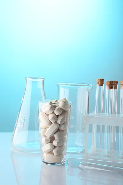Empty laboratory test tubes and glass of pills — Stock Photo, Image