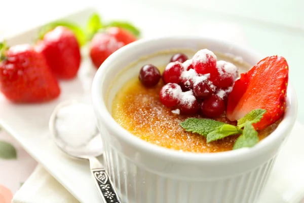 Creme Brulee Dessert mit frischen Erdbeeren und Minzblättern, auf farbigem Holzhintergrund — Stockfoto