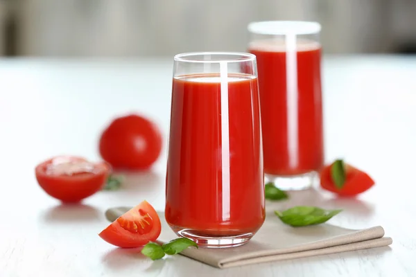 Jugo de tomate y tomates frescos en primer plano de mesa de madera — Foto de Stock