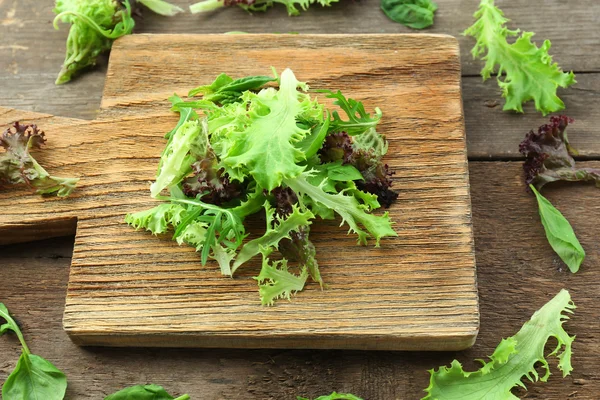 Ahşap kesim tahtasında karışık yeşil salata, yakın plan. — Stok fotoğraf