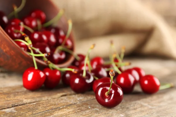 Frische Kirschen in Schale auf Holztisch mit Sacktuch, Nahaufnahme — Stockfoto