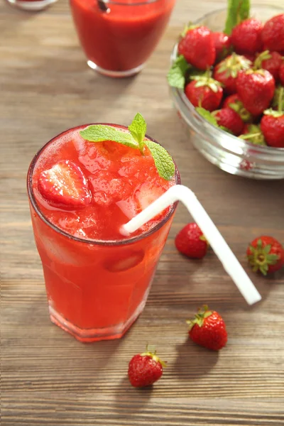 Glasses of strawberry juice with berries on table close up — Stock Photo, Image