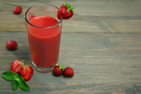 Glas strawberry smoothie met bessen op houten tafel close-up — Stockfoto