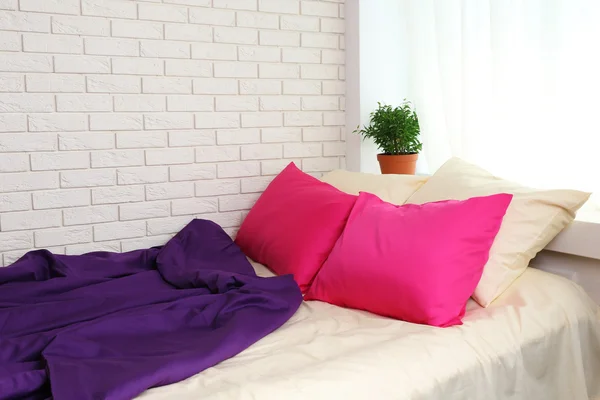 Bequemes Bett mit rosa Kissen — Stockfoto