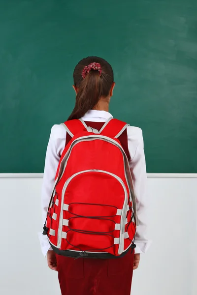 Girl standing near blackboard in — Stock Photo, Image