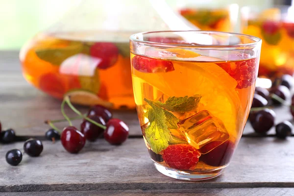 Punch with berries in glassware on wooden table, closeup — Stock Photo, Image