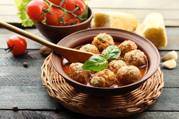 Bolas de carne con salsa de tomate, cuchara de madera sobre fondo de madera —  Fotos de Stock