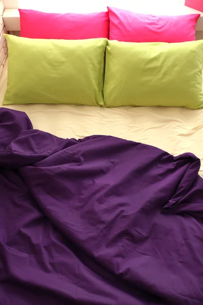 Bequemes Bett mit bunten Kissen — Stockfoto