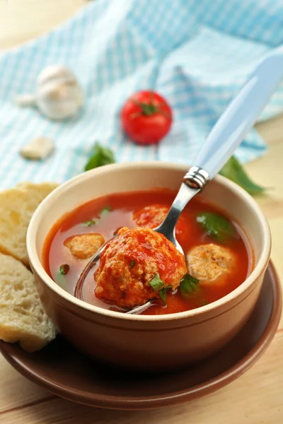 Tomato soup with meat balls on wooden spoon on wooden background — Stock Photo, Image