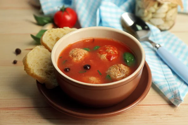 Tomato soup with meat balls on wooden spoon on wooden background — Stock Photo, Image