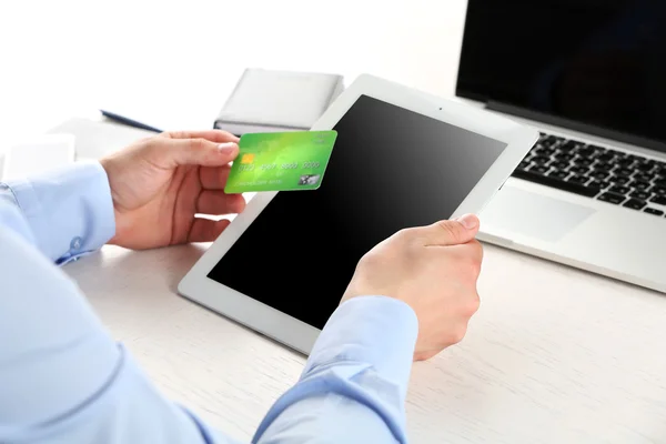 Uomo in possesso di carta di credito e tablet — Foto Stock