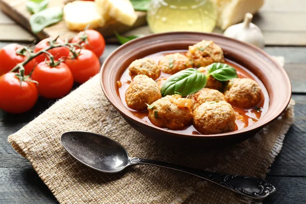 Meat balls with tomato sauce, wooden spoon on wooden background — Stock Image Meat balls with tomato sauce, wooden spoon on wooden background Royalty Free Stock Photos