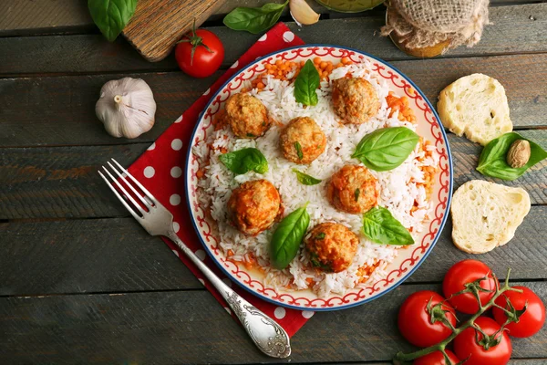Meat balls in tomato sauce with boiled rice and lentil, wooden spoon on wooden background — Stock Image Meat balls in tomato sauce with boiled rice and lentil, wooden spoon on wooden background Royalty Free Stock Images
