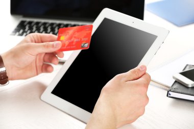 Kredi kartı ve tablet işyeri arka planda tutan adam