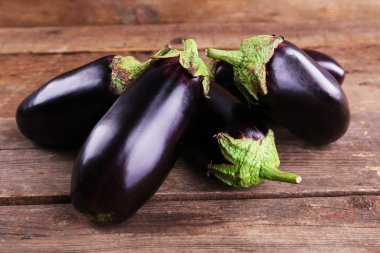 Fresh eggplant on wooden background clipart
