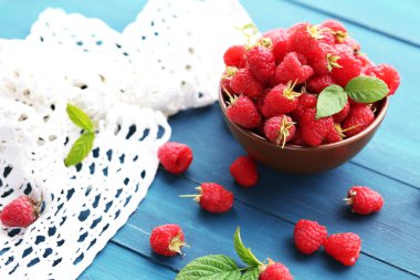 Mavi ahşap zemin üzerine kase taze frambuaz