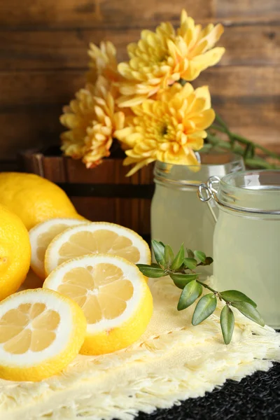 Bodegón con jugo de limón y limones en rodajas sobre fondo de madera —  Fotos de Stock