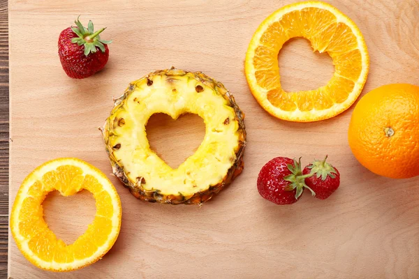 Fruchtscheiben mit herzförmigem Schnitt und Beeren auf dem Tisch aus nächster Nähe — Stockfoto