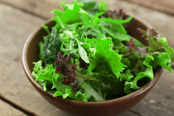Kase üzerinde ahşap masa, closeup karışık yeşil salata — Stok fotoğraf