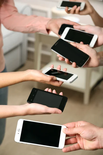 Muchas manos sosteniendo teléfonos móviles —  Fotos de Stock
